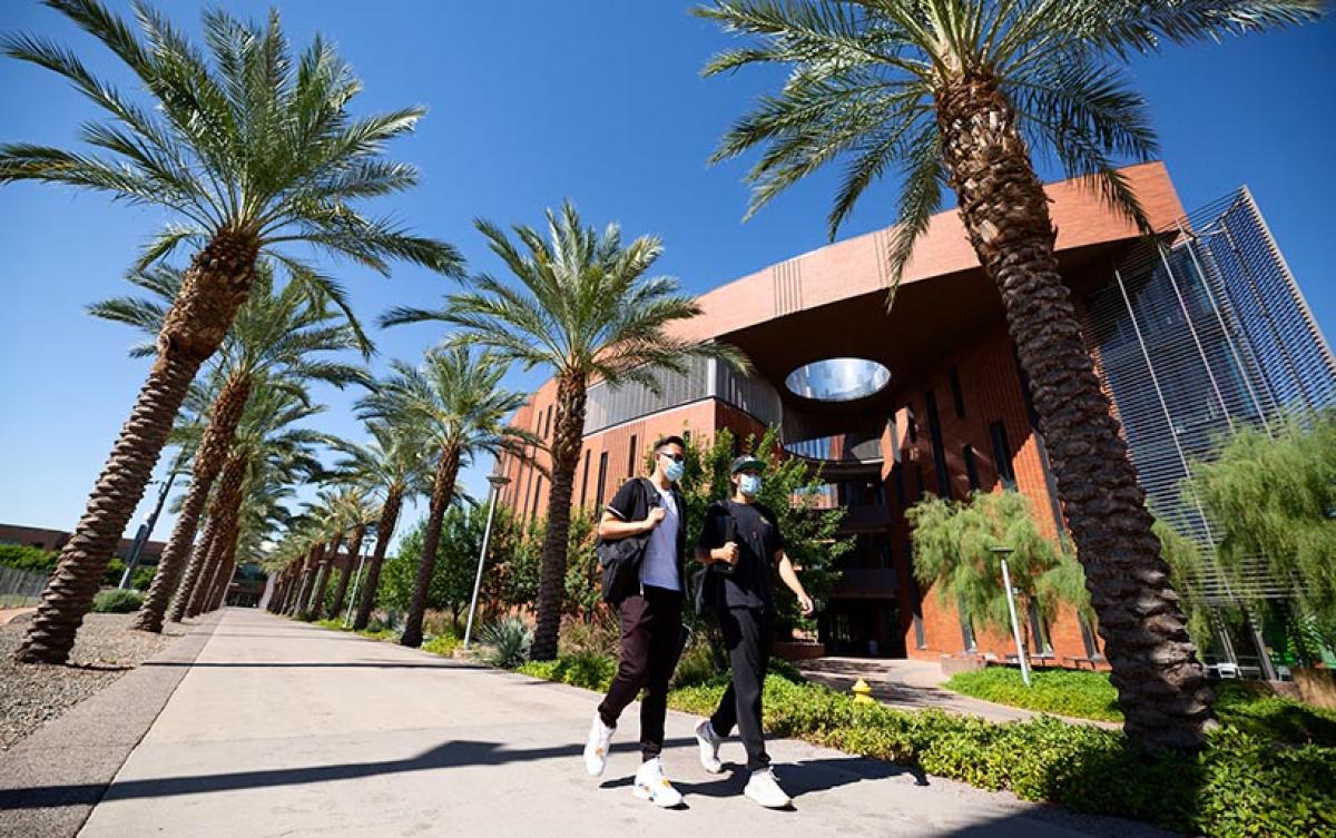 two students walking by W.P.Carey school of business on ASU Tempe campus